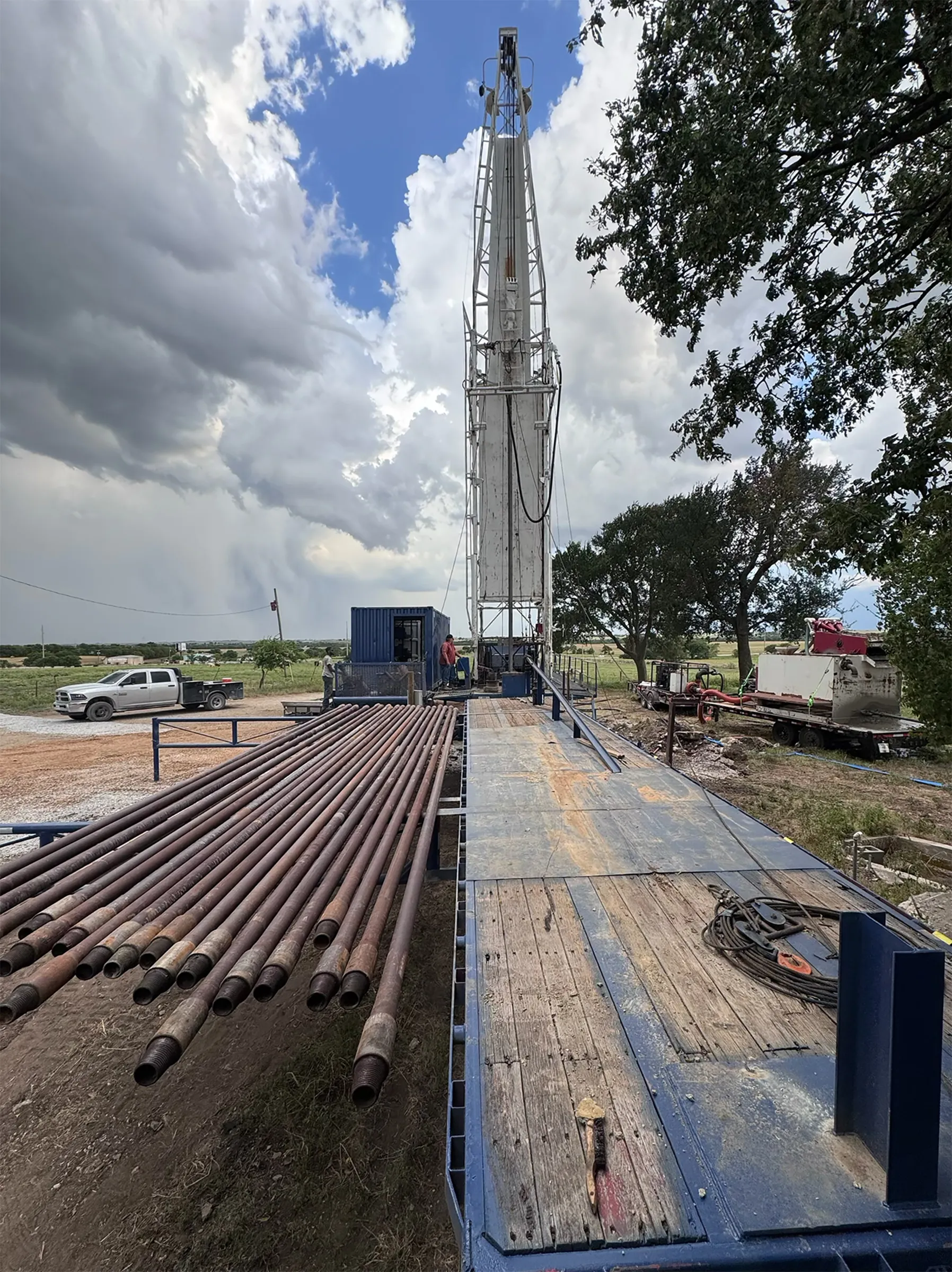 DFW Well Service deep water well drilling rig, mast raised, on a North Texas job site