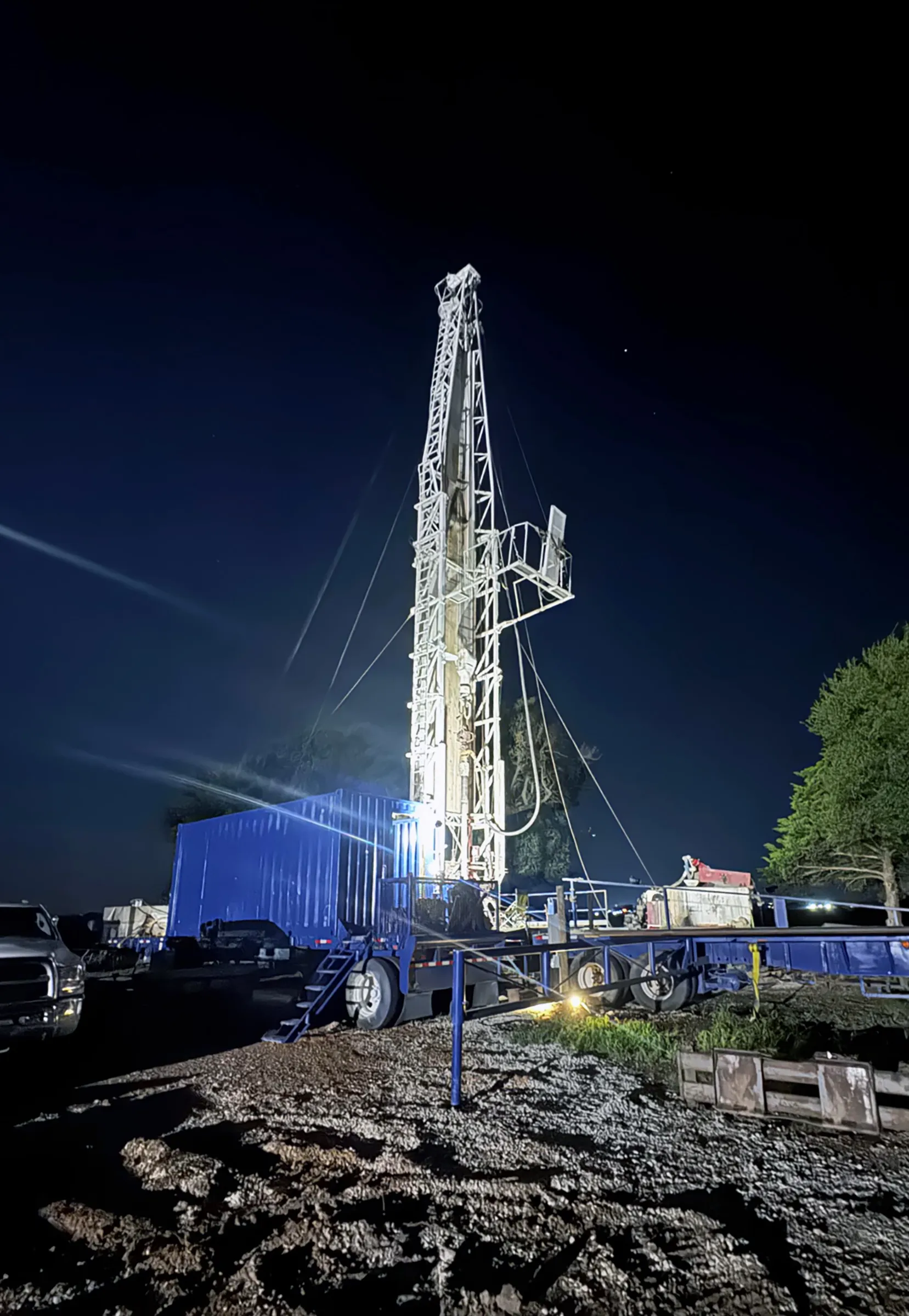 Water well drilling rig working after dark in North Texas